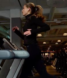 a woman running on a treadmill in a gym