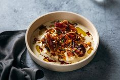 a bowl filled with yogurt and nuts on top of a blue table cloth