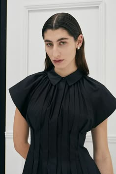 The signature Unchartered shirt dress in Cotton returns, in the much anticipated Black colour this season. Find out why so many have fallen in love with this style, with its uniquely tapered box pleats at the waist, giving the dress a flattering silhouette. The style also features open shaped sleeves and a concealed button front opening and side pockets for ease of wear. Colour: Black Also available in Ivory and Lilac colour-ways. Fit: Regular fit overall, slim fitting at waist.Model is wearing Long Dress Style, Black Dress Style, Bauhaus Architecture, Fashion Trend Report, Lilac Colour, Sage Green Bridesmaid Dress, Elegant Pumps, Black Pleated Dress, Garment Care Labels