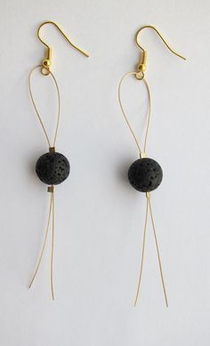 pair of black stone and gold - plated earwires on white background, closeup