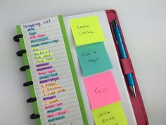 a notebook with sticky notes attached to it and a pen sitting on top of it