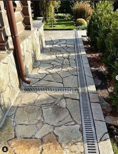 a metal grate sitting on top of a stone walkway