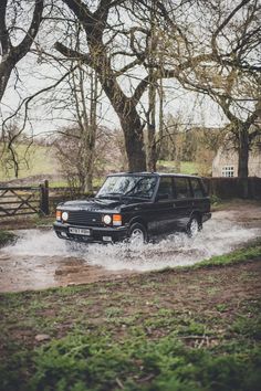 a black land rover driving through some water