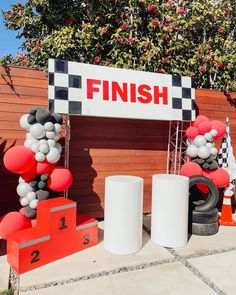 the finish line is decorated with balloons and race track numbers for an event or competition