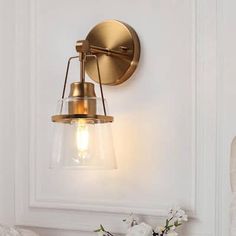 Add a touch of elegance and sophistication to your living space with the 1-Light Plated Brass Mid-Century Modern Wall Sconce. This stunning wall-mounted lighting fixture is part of a distinguished collection that seamlessly blends vintage charm with contemporary design elements. Finished in plated brass, this wall sconce radiates a warm and inviting ambiance, creating a focal point that enhances the overall aesthetic of your room. Its sleek and minimalist design complements a range of interior styles, making it a versatile choice for any decor theme. Featuring a single E26 socket, this wall sconce provides focused and adjustable illumination to highlight specific areas or create a cozy atmosphere. The clear glass shade, with its elegant bell-shaped silhouette, adds a touch of timeless beau Modern Bathroom Vanity Lighting, Brass Vanity Light, Modern Plates, Black Wall Lights, Indoor Wall Sconces, Bathroom Vanity Light, Mid Century Modern Walls, Modern Wall Sconces, Bathroom Wall Sconces