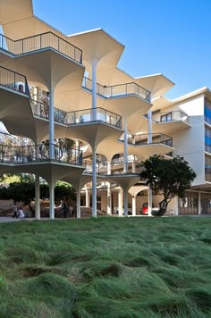 several balconies and balconies on the side of a building with grass in front of them