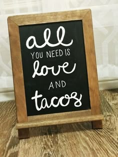 a chalkboard sign that says all you need is love and tacos on it