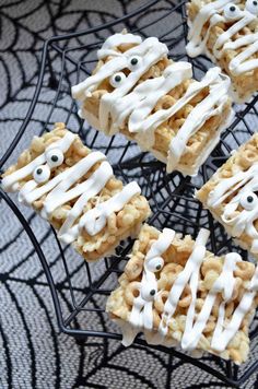 halloween treats with eyes and googly eyes are on a wire rack in front of a spider web