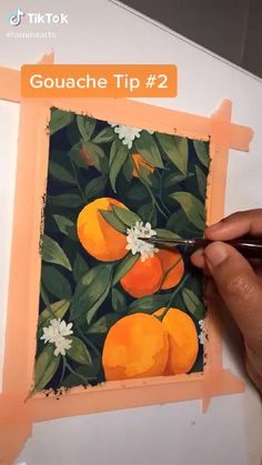 someone is painting oranges on a piece of paper