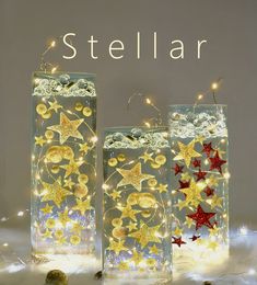 three glass vases with lights and stars in them