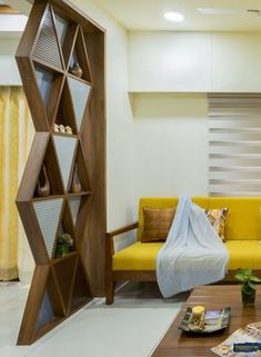 a living room with yellow couches and bookshelves on the wall behind it