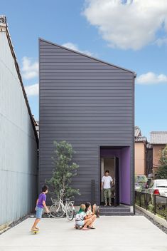 kids playing outside in front of a house with purple walls and doors on the side