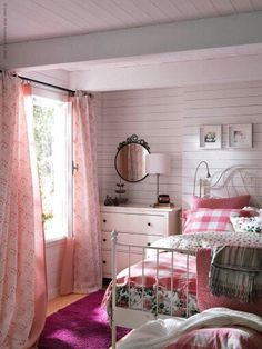 an image of a bedroom with pink and white decor on the walls, bedding and curtains