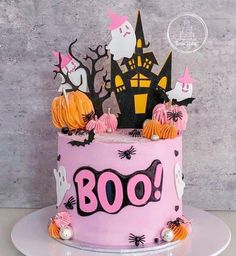 a halloween cake with pink frosting and decorations