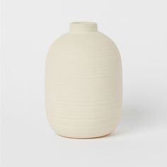 a white vase sitting on top of a table