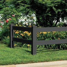 a wooden bench sitting in the grass next to flowers