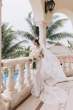 a woman in a wedding dress standing on a balcony