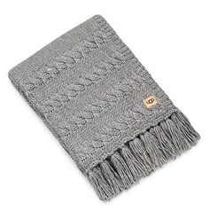 a gray scarf with fringes on the ends and an orange tag hanging from it