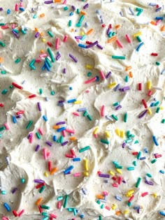 a cake with white frosting and sprinkles on it's edges