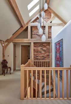 an open loft with exposed brick walls and wooden railings on the second floor is shown