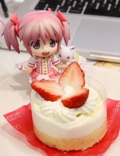 a strawberry shortcake sitting on top of a table next to a laptop