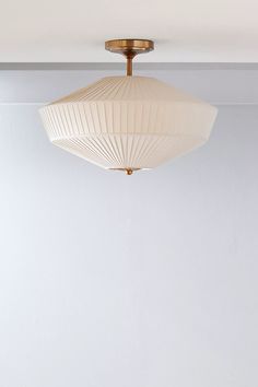 a light fixture hanging from the ceiling in a room with white walls and flooring