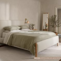 a bedroom with a bed, mirror and plant on the wall in front of it