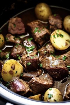 a pot filled with beef and potatoes on top of a stove