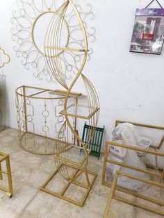 three metal sculptures sitting next to each other on top of a tile floor in front of a white wall