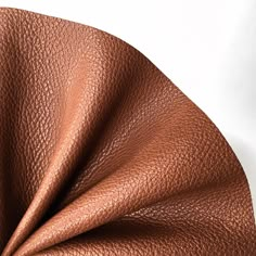 a close up view of a brown leather textured material on a white tablecloth