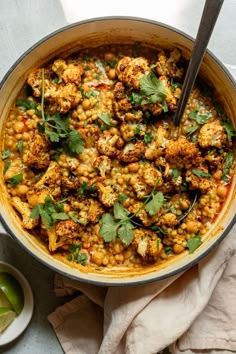 a pan filled with cauliflower, chickpeas and cilantro sauce