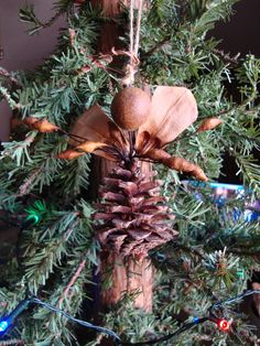 a pine cone ornament hanging from a tree