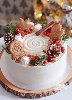 a white frosted cake decorated with cookies and other holiday decorations on a wooden platter