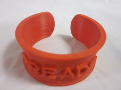 an orange rubber bracelet with the word bead on it