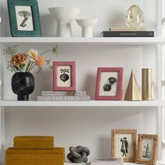 three white shelves with pictures, vases and other decorative items on top of them