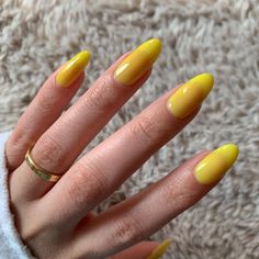 a woman's hand with yellow nail polish on it