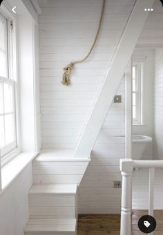 a white staircase leading up to a bathroom in a house with wood floors and walls