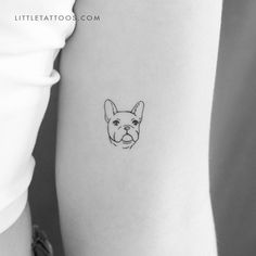 a small dog's face is shown on the back of a woman's arm