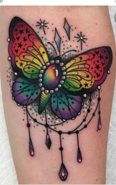 a colorful butterfly tattoo on the left thigh and right leg, with drops coming out of it