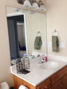 a bathroom with a sink, mirror and hanging lights