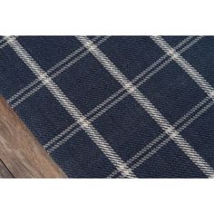 the blue and white plaid rug is laying on top of a wooden flooring board