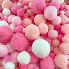 pink and white pom - poms are scattered together