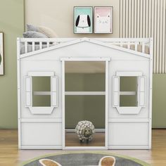 a white dog house with two windows and a sheep head on the floor in front of it