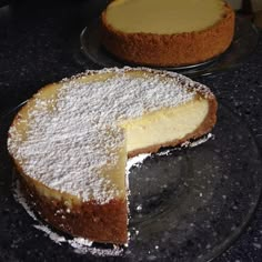 two cakes sitting on top of glass plates covered in powdered sugar