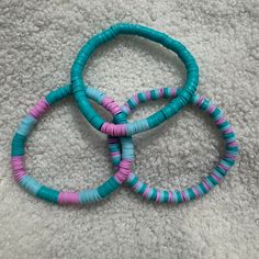 Handcrafted bracelets consisting of teal, pink, and light blue Heishi clay beads, designed as stretchy bracelets. Size of bracelet in photo: 7 1/2 inches Bracelets Clay, Heishi Bead Bracelet, Bracelet Trio, Clay Bead Bracelets, Clay Bead Bracelet, Clay Bead, Handcrafted Bracelets, Stackable Bracelets, Tie Styles