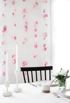 a white table topped with candles and pink paper hearts