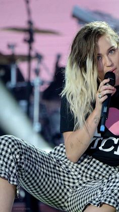 a woman sitting on top of a chair holding a microphone