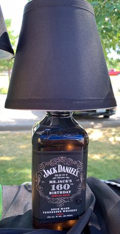 a lamp that is sitting on top of a table next to a bottle with a label on it