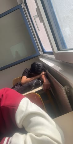 a woman is sleeping on her desk by the window