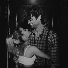 black and white photograph of two people hugging each other in front of an elevator door